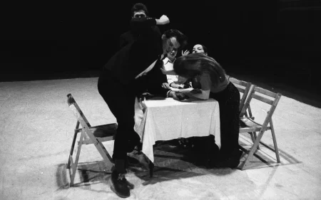 Przy stole siedzi grupa aktorów i aktorek. Na pierwszym planie aktor wygląda, jakby bił aktorkę.