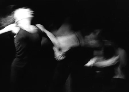 Niewyraźne, rozmazane zdjęcie. Aktorka z lewej strony oraz osoby z prawej strony wykonują ekspresyjne ruchy. Prawdopodobnie trzymają się za ręce.