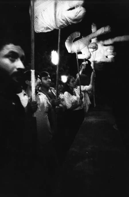 Grupa aktorów i aktorek zwróconych w stronę widza profilem. Niektórzy trzymają w rękach wielkie dłonie na kijach.