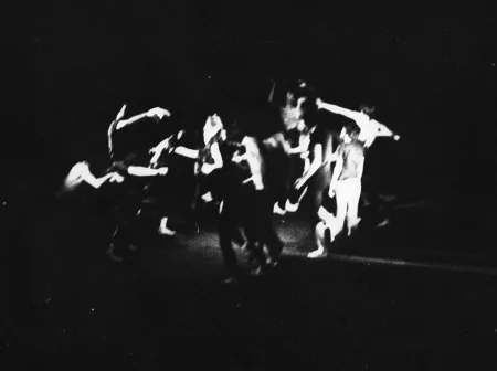 Niewyraźne, rozmazane zdjęcie. Grupa aktorów ustawiona w kole wygląda, jakby tańczyła.