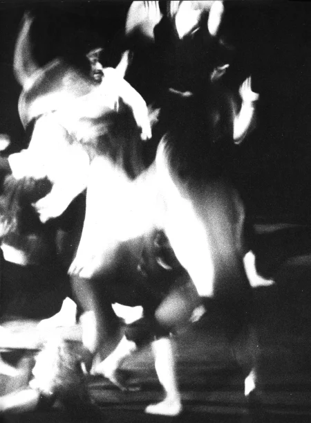 Niewyraźne, rozmazane zdjęcie. Grupa bosych aktorów wygląda, jakby tańczyła.