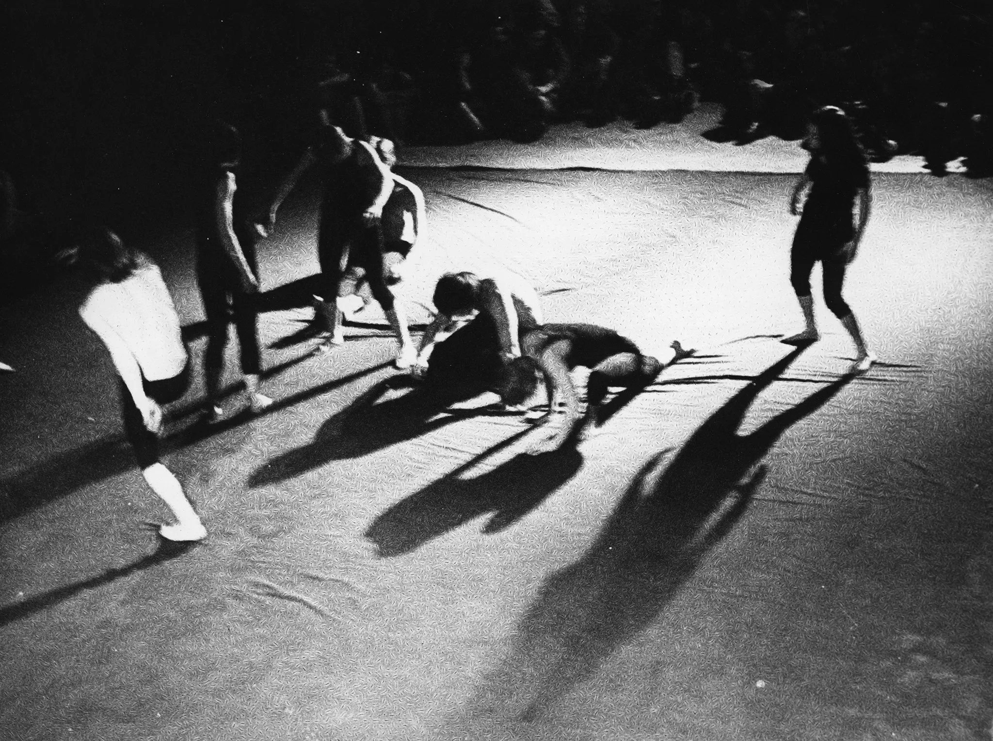 Scena wyglądająca jak wyłożona prześcieradłem. Na scenie grupa aktorów i aktorek widzianych od góry.Dynamicznie ruszają się w różne strony. Na drugim planie siedząca grupa widzów.