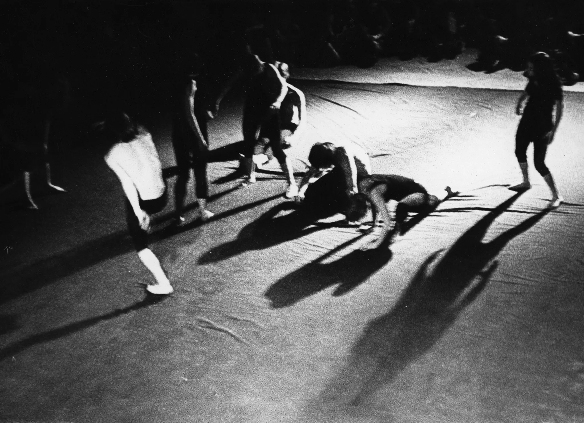 Scena wyglądająca jak wyłożona prześcieradłem. Na scenie grupa aktorów i aktorek widzianych od góry.Dynamicznie ruszają się w różne strony. Na drugim planie siedząca grupa widzów.