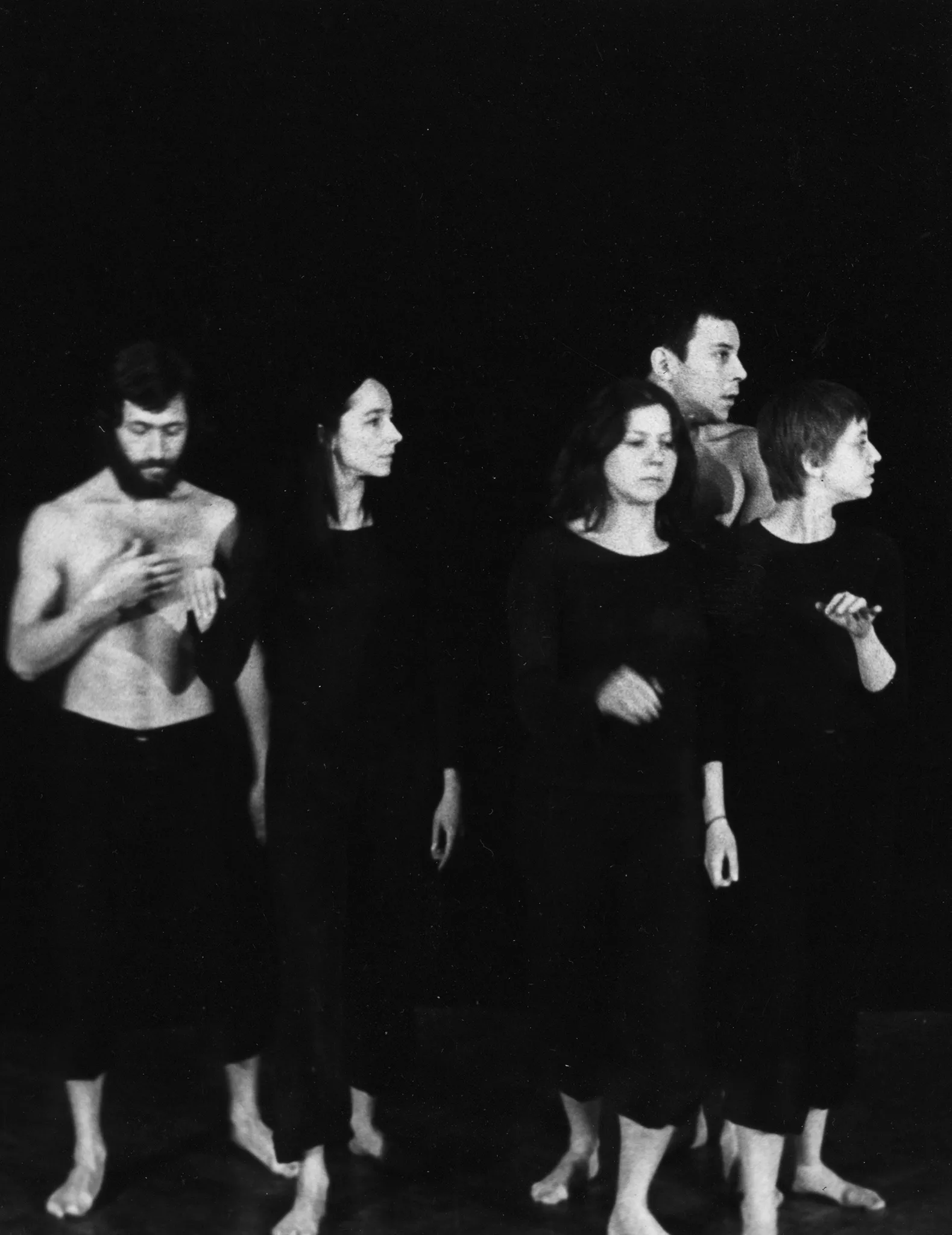 Trzy aktorki i dwóch aktorów. Stoją zwróceni profilem w stronę widza. Aktorzy ubrani są w czarne spodenki i mają nagie torsy. Aktorki ubrane są w czarne spodnie i czarne koszulki. Wszyscy są boso.