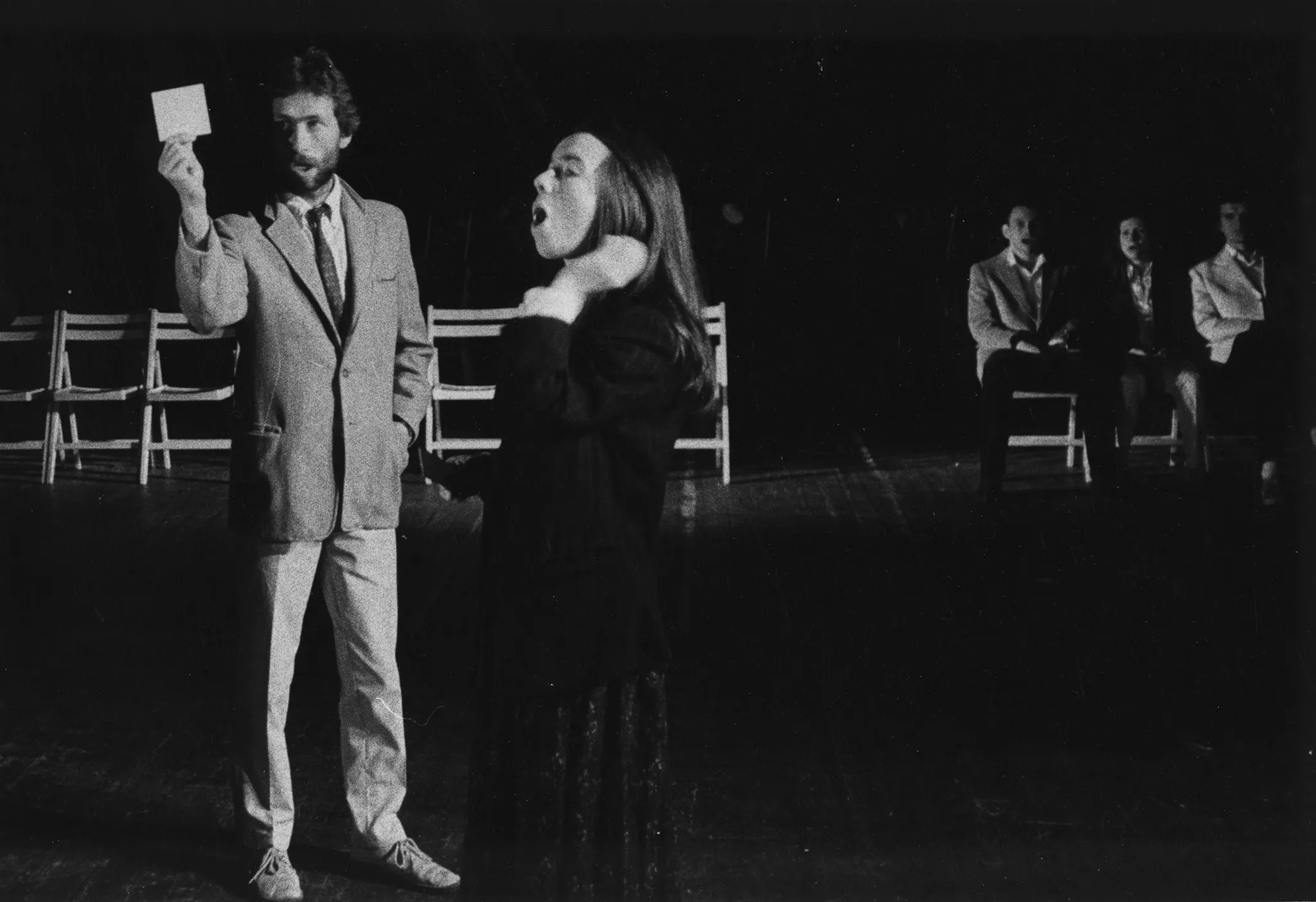 Ptrzestrzeń miejska. Ulica między budynkami jest pusta. Drzwi i okna budynków zasłonięte są białymi płachtami.