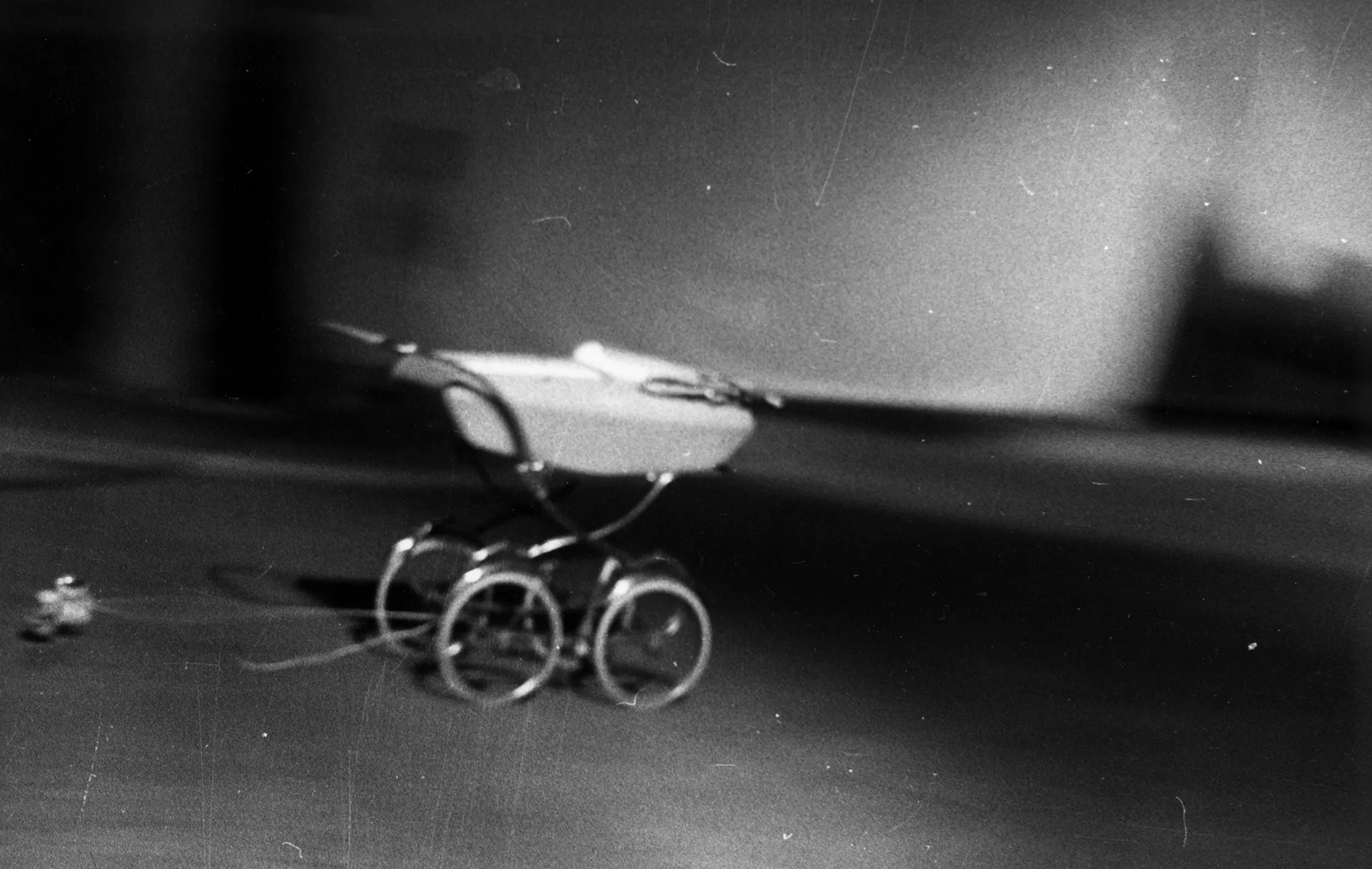 Rozmazane zdjęcie. Wózek dziecięcy ciągniący na lince nieokreślony przedmiot.