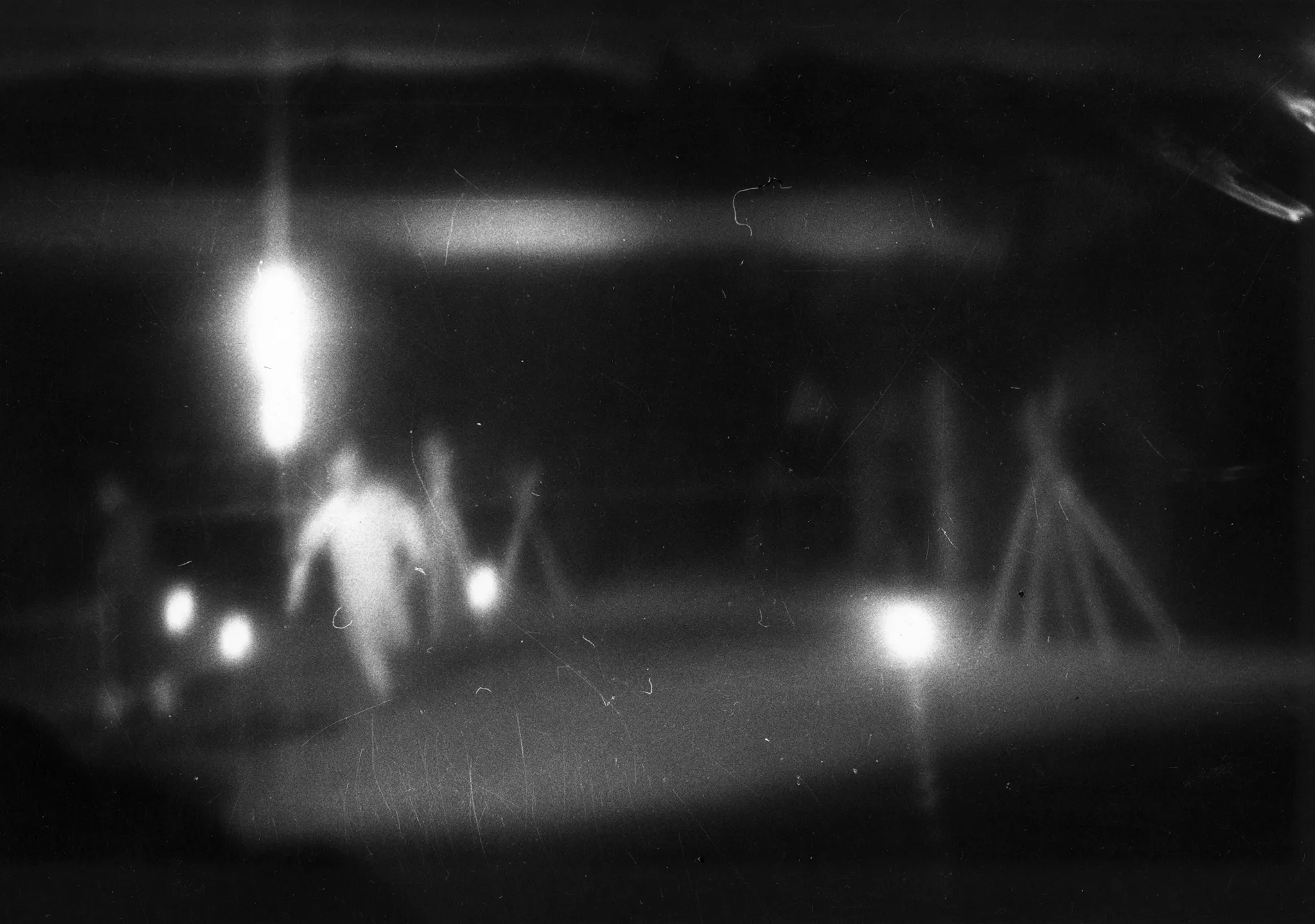 Niewyraźne zdjęcie. W oddali widać biegnącego aktora i kilka świecących reflektorów.